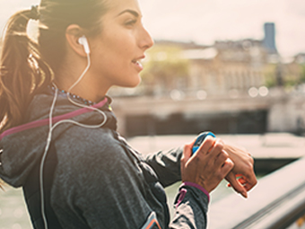 Woman checking her smart watch while jogging